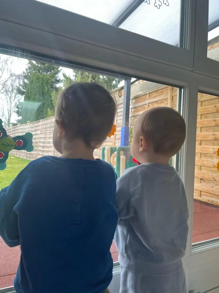 Enfants de dos à la micro crèche de Hallencourt qui regarde l'extérieur